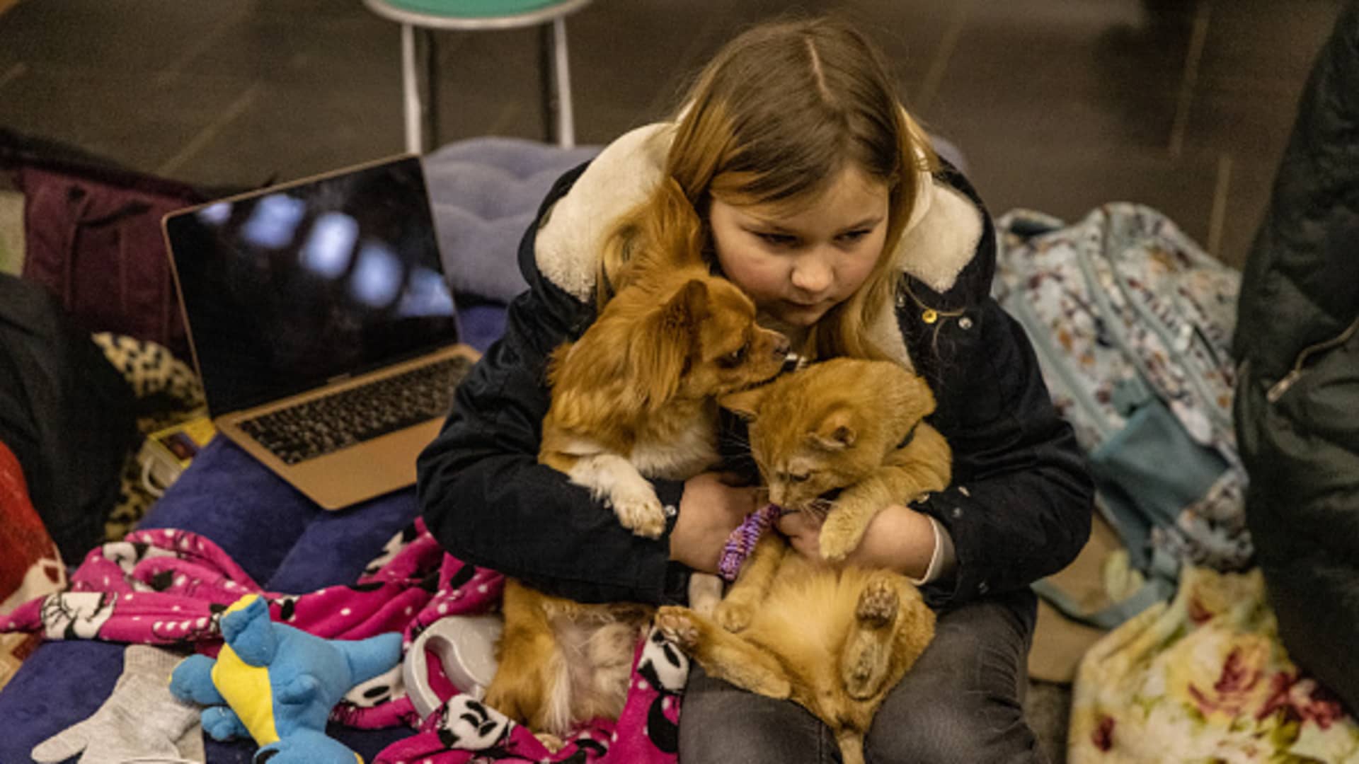 A girl sits with her dog and cat in the Dorohozhychi subway station which has has been turned into a bomb shelter on March 02, 2022 in Kyiv, Ukraine.