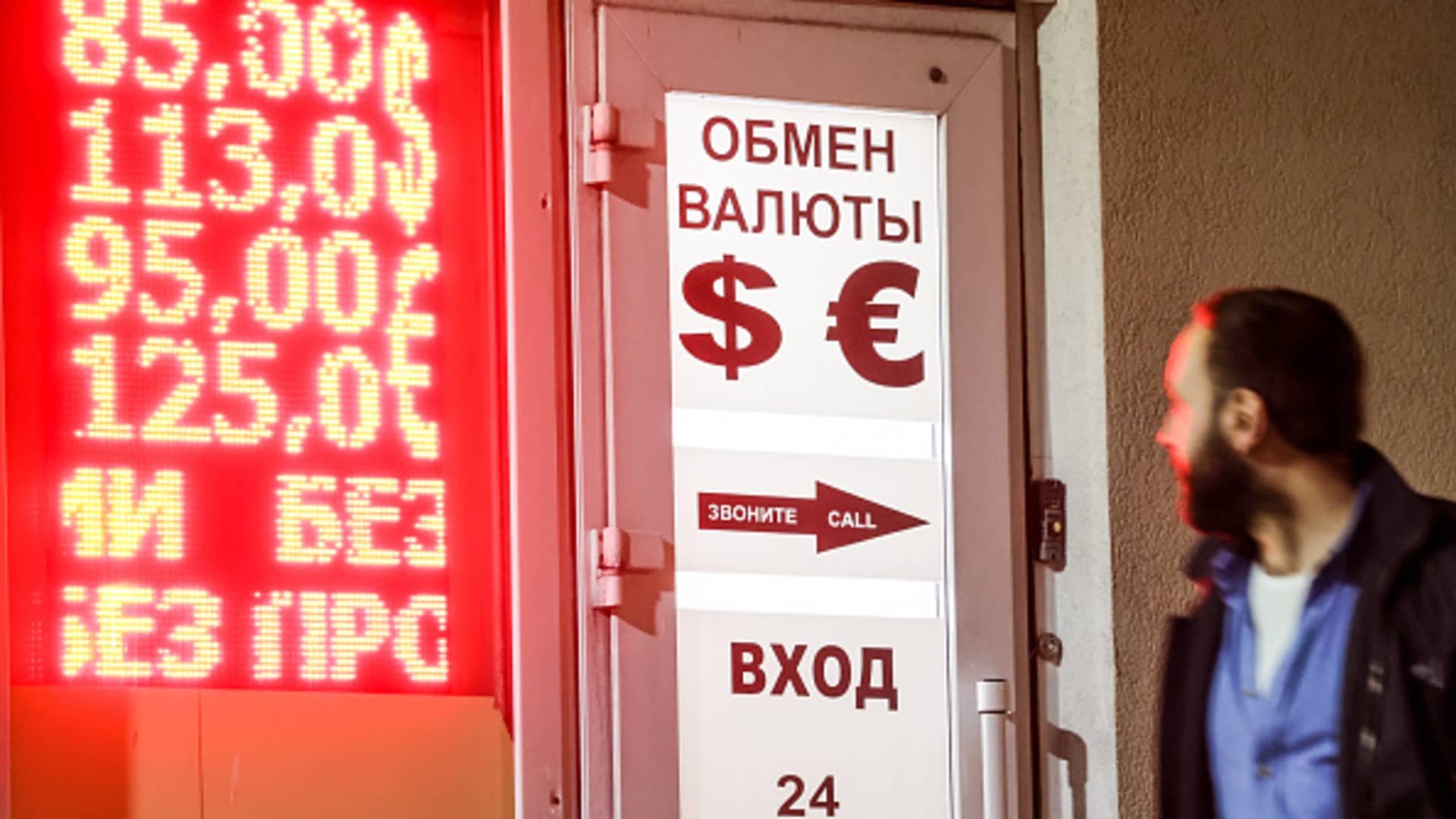 A man views a digital board showing Russian rouble exchange rates against the euro and the US dollar outside a currency exchange office. On March 2, 2022, the Russian rouble hit record lows with the US dollar and the euro rates reaching 110 and 122 at the Moscow Exchange respectively.