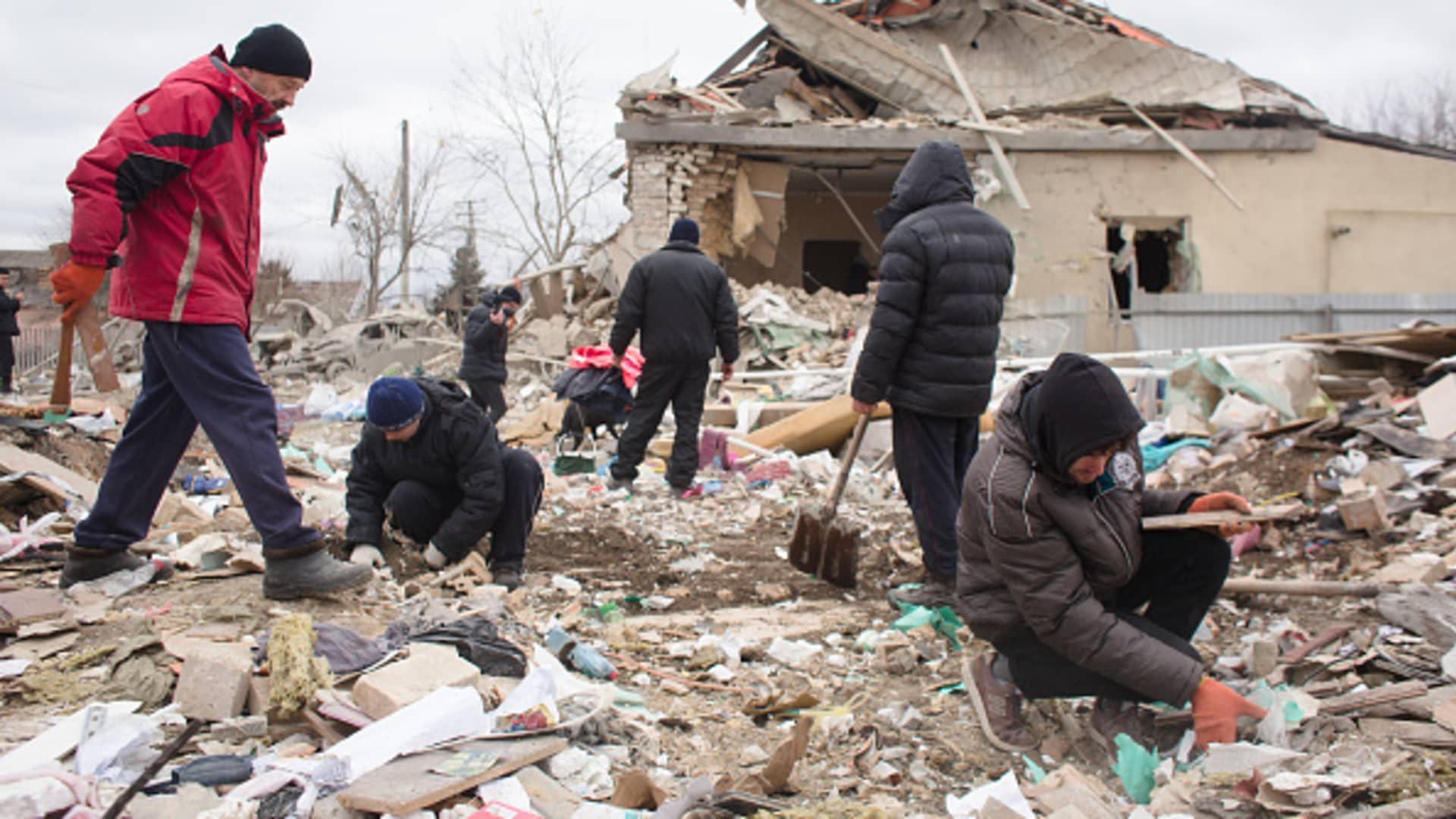 Neighbors and relatives help remove the rubble of a house destroyed with shelling on March 5, 2022 in Markhalivka, Ukraine.