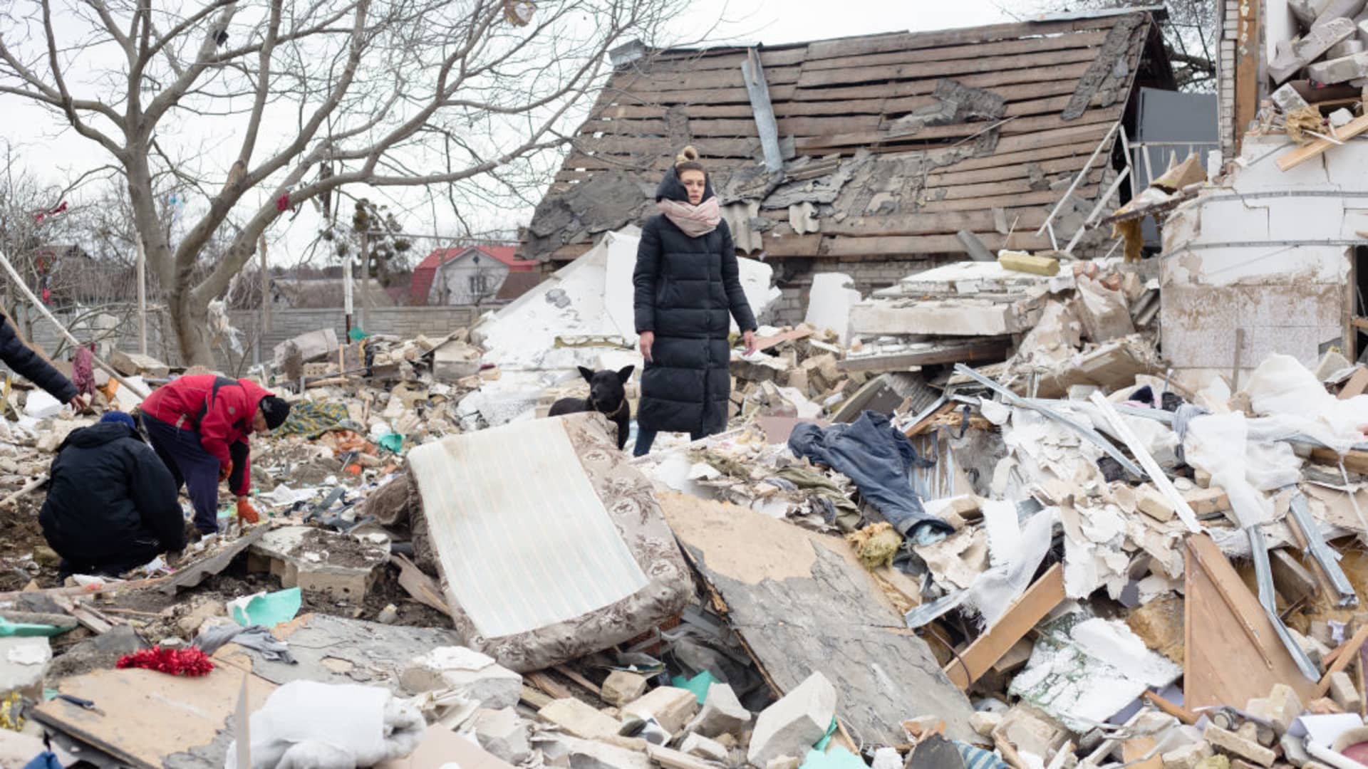 Kateryna Ralchuk, the niece of Ihor Mazhayev who's house was shelled, helps to remove the rubble after the shelling on March 5, 2022 in Markhalivka, Ukraine.