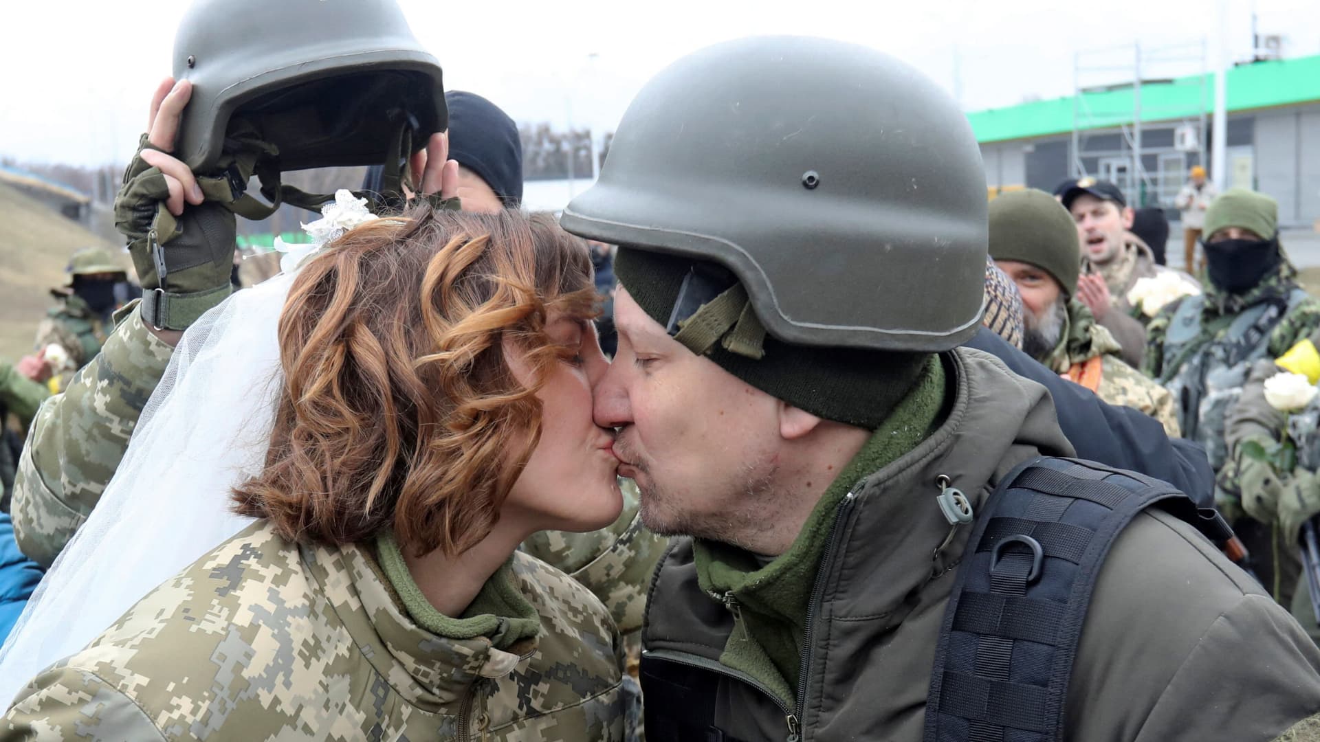 Members of the Ukrainian Territorial Defence Forces Lesia Ivashchenko and Valerii Fylymonov kiss at their wedding during Ukraine-Russia conflict, at a checkpoint in Kyiv, Ukraine March 6, 2022.