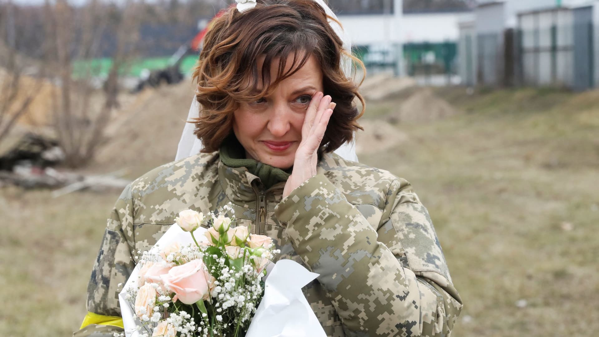 A member of the Ukrainian Territorial Defence Forces Lesia Ivashchenko reacts at her wedding with Valerii Fylymonov during Ukraine-Russia conflict, at a checkpoint in Kyiv, Ukraine March 6, 2022.