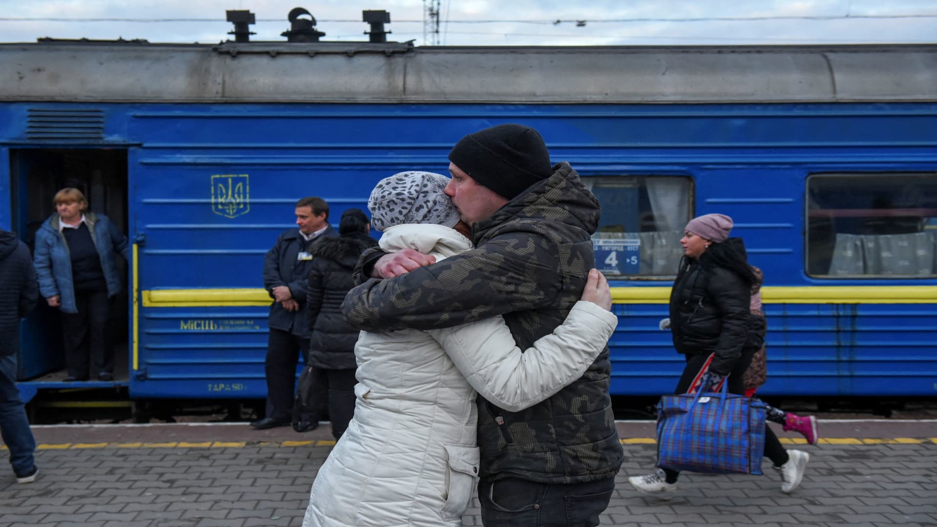 A couple embraces as passengers, including people fleeing Russia's invasion of Ukraine, board a train to leave the city of Odessa, Ukraine, March 6, 2022.