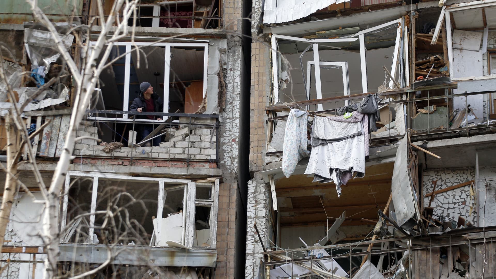 A resident looks out of the destroyed front of a room in a multi-storey building that was badly damaged as a result of Russian missile explosion after it was shot down over the city by Ukrainian air defence on March 6, in Kramatorsk on March 7, 2022.