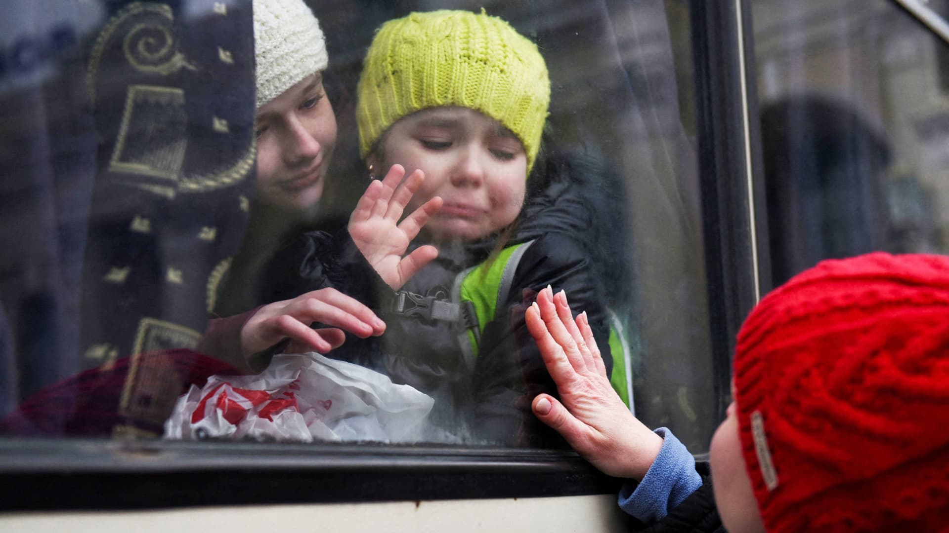Alexandra, 12, holds her sister Esyea, 6, who cries as she waves at her mother, Irina, while members of the Jewish community of Odesa board a bus to flee Russia's invasion of Ukraine, in Odesa, Ukraine, March 7, 2022.