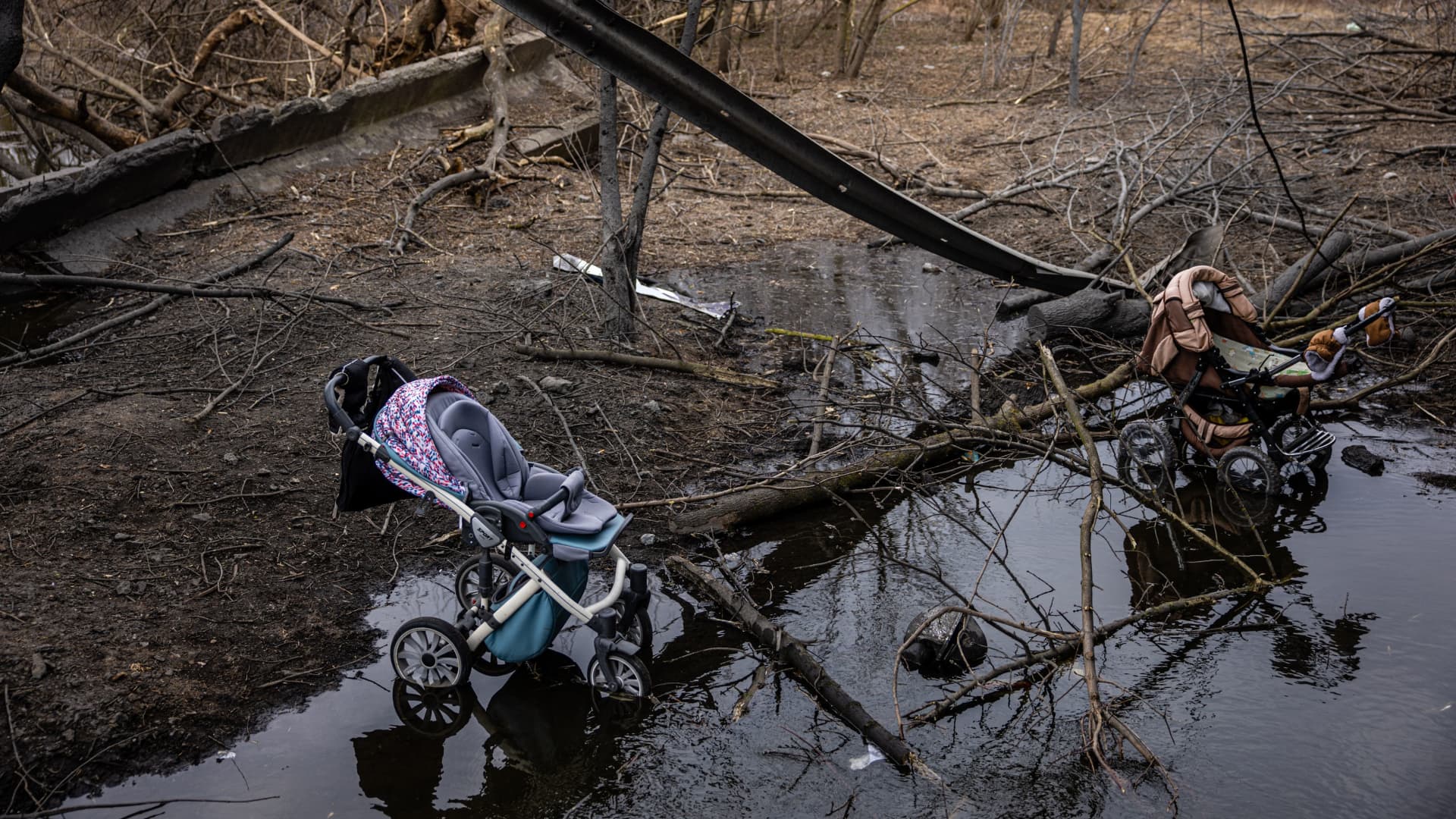 Abandoned strollers are pictured under a destroyed bridge as people walked across the collapsed concrete to flee Irpin, a northwest suburb of Kyiv, on March 7, 2022.