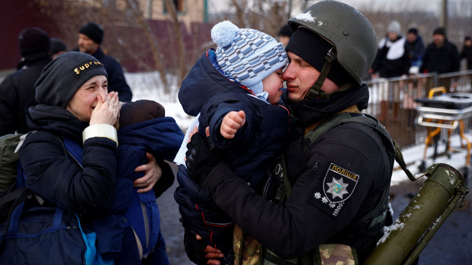 A police officer says goodbye to his son as his family flees from advancing Russian troops as Russia's attack on Ukraine continues in the town of Irpin outside Kyiv, Ukraine, March 8, 2022.