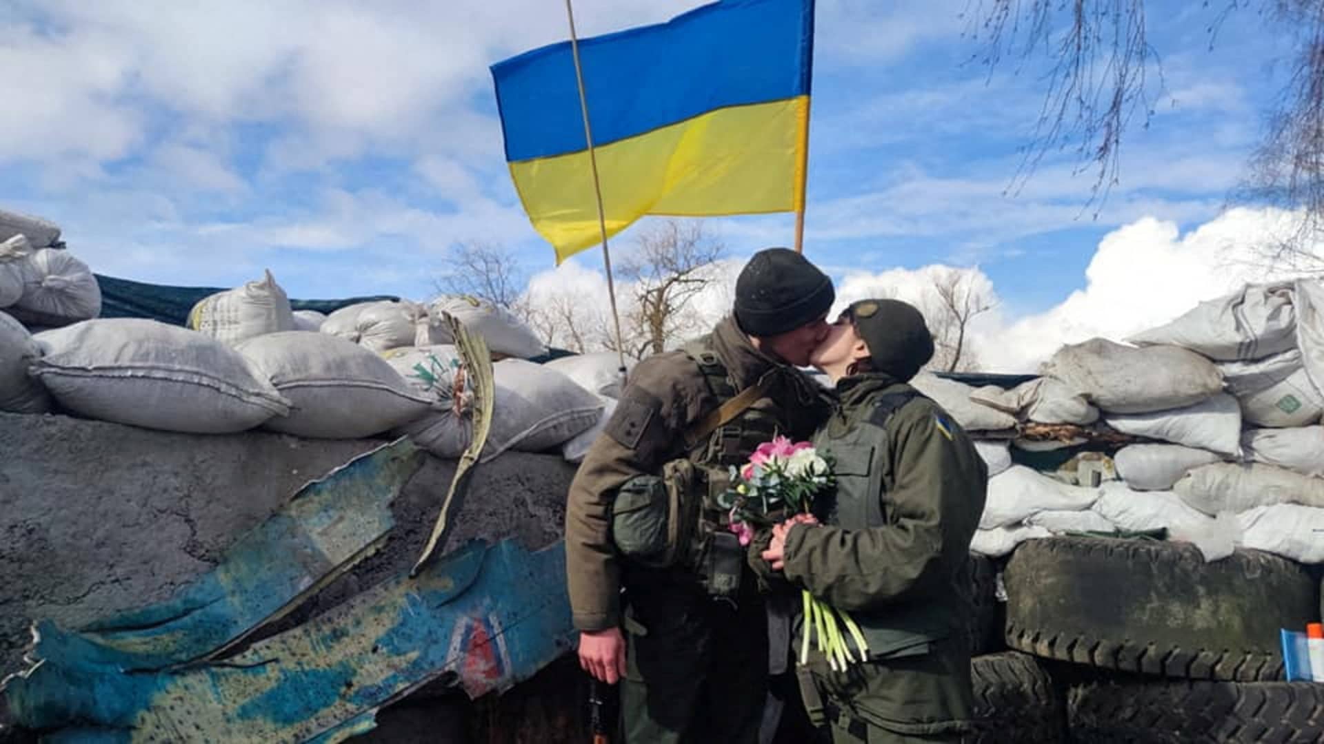 Members of the National Guard of Ukraine Oleksandr and Olena kiss at their wedding during Ukraine-Russia conflict, at a checkpoint in unknown location, in Ukraine, in this handout picture released March 8, 2022.