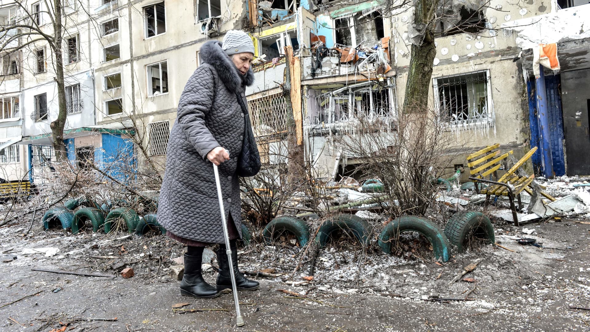 A woman walks by apartment building damaged after shelling the day before in Ukraine's second-biggest city of Kharkiv on March 8, 2022.