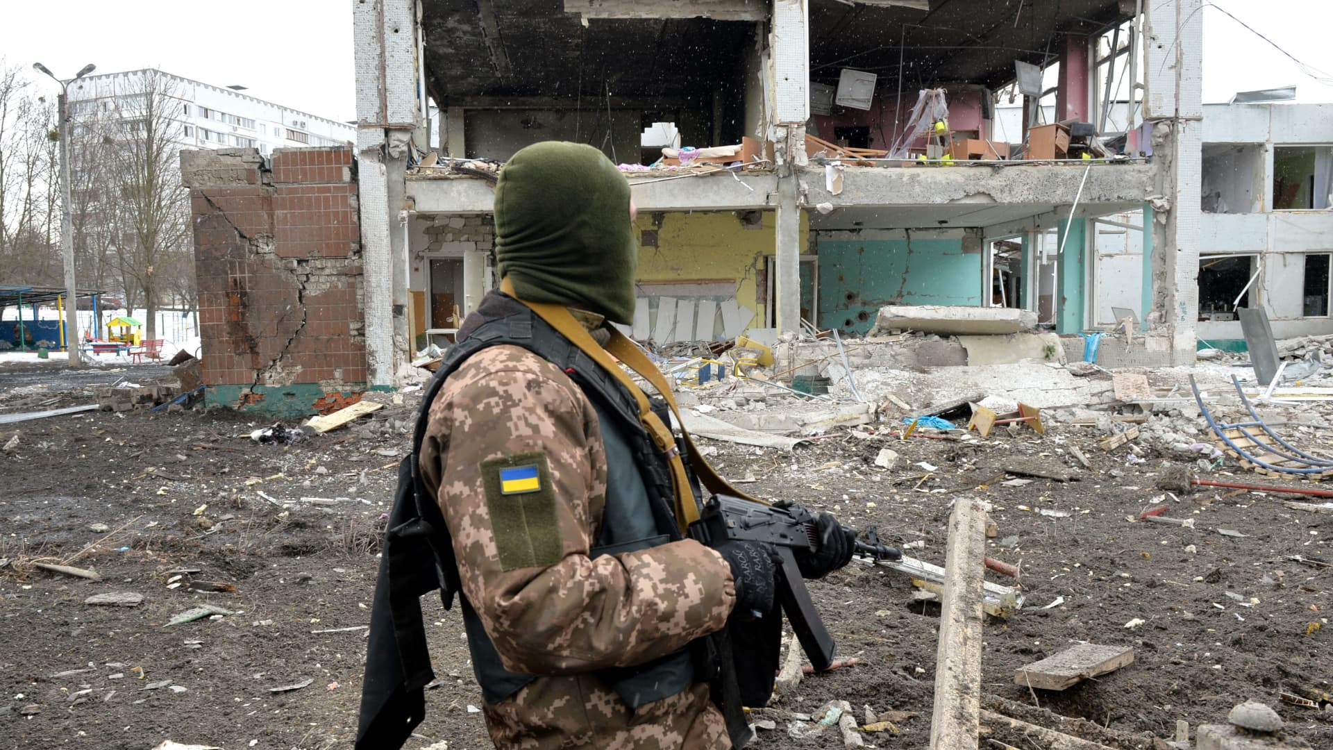 A member of the Ukrainian Territorial Defence Forces looks at destructions following a shelling in Ukraine's second-biggest city of Kharkiv on March 8, 2022.