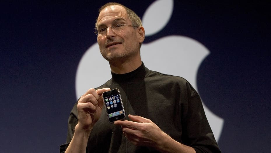 SAN FRANCISCO, CA - JANUARY 9: Apple CEO Steve Jobs holds up the new iPhone that was introduced at Macworld on January 9, 2007 in San Francisco, California. The new iPhone will combine a mobile phone, a widescreen iPod with touch controls and a internet c