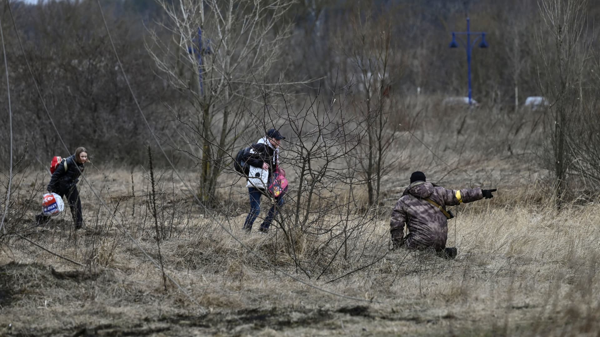 A Ukrainian soldier directs civilians fleeing Irpin, west of Kyiv, as fighting rages around the city on March 7, 2022.