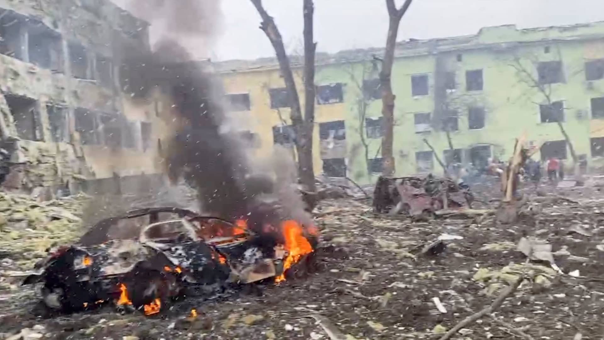 A car burns after the destruction of Mariupol children's hospital as Russia's invasion of Ukraine continues, in Mariupol, Ukraine, March 9, 2022 in this still image from a handout video obtained by Reuters.