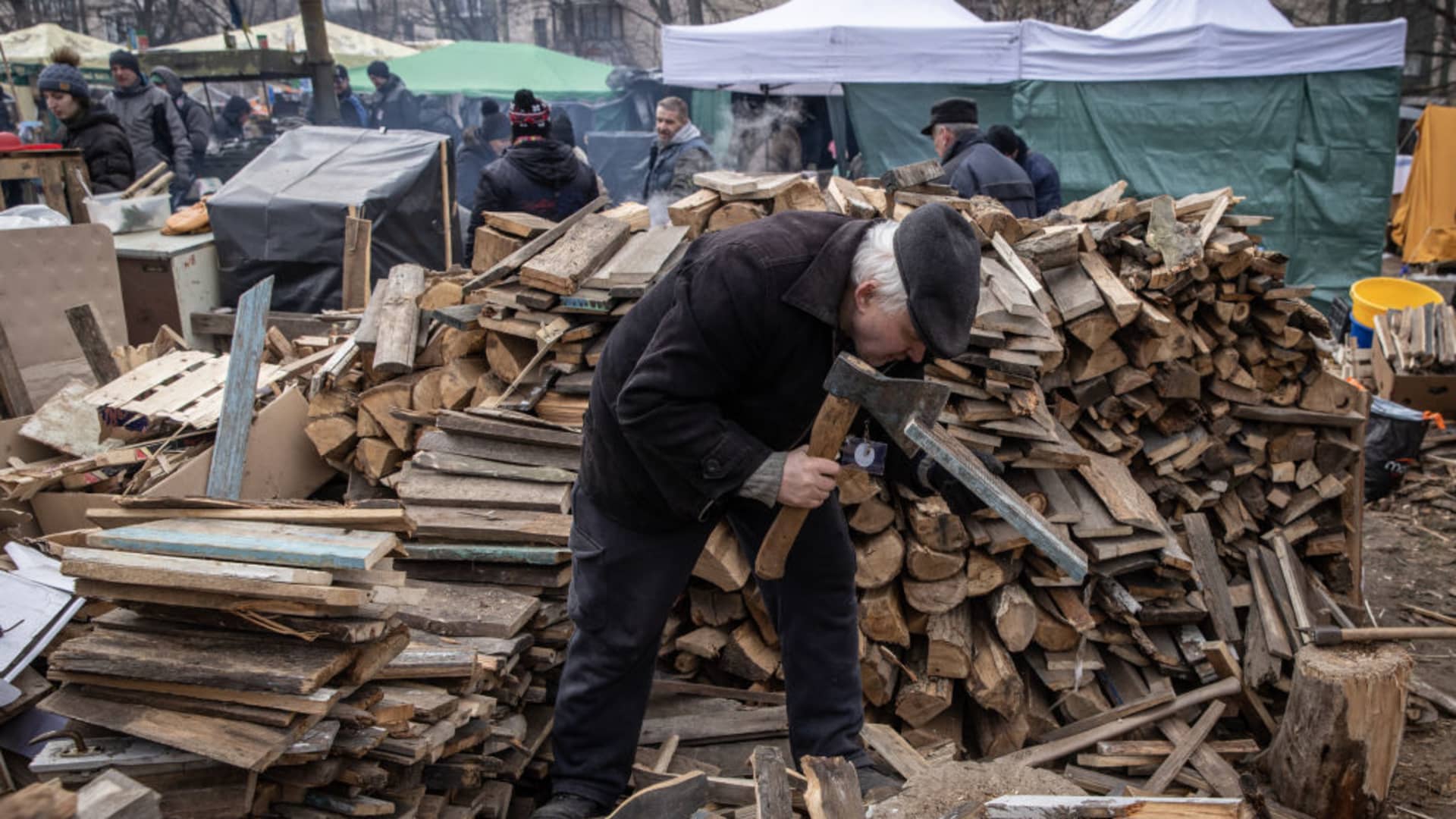 A volunteer cuts wood for fires at a roadside camp setup to help serve meals and assist civilians and soldiers close to the north eastern frontline on March 09, 2022 in Kyiv, Ukraine.