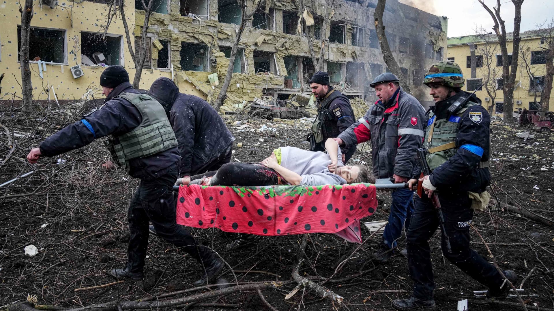 Ukrainian emergency employees and volunteers carry an injured pregnant woman from a maternity hospital that was damaged by shelling in Mariupol, Ukraine, Wednesday, March 9, 2022.