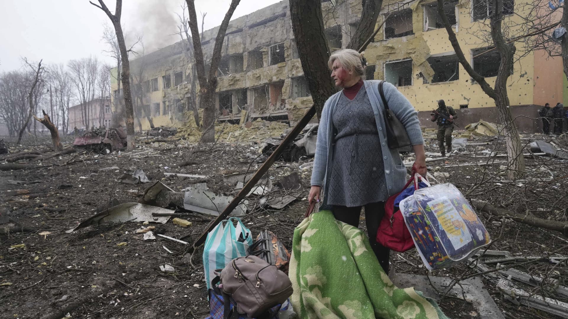 A woman walks outside a maternity hospital that was damaged by shelling in Mariupol, Ukraine, Wednesday, March 9, 2022.