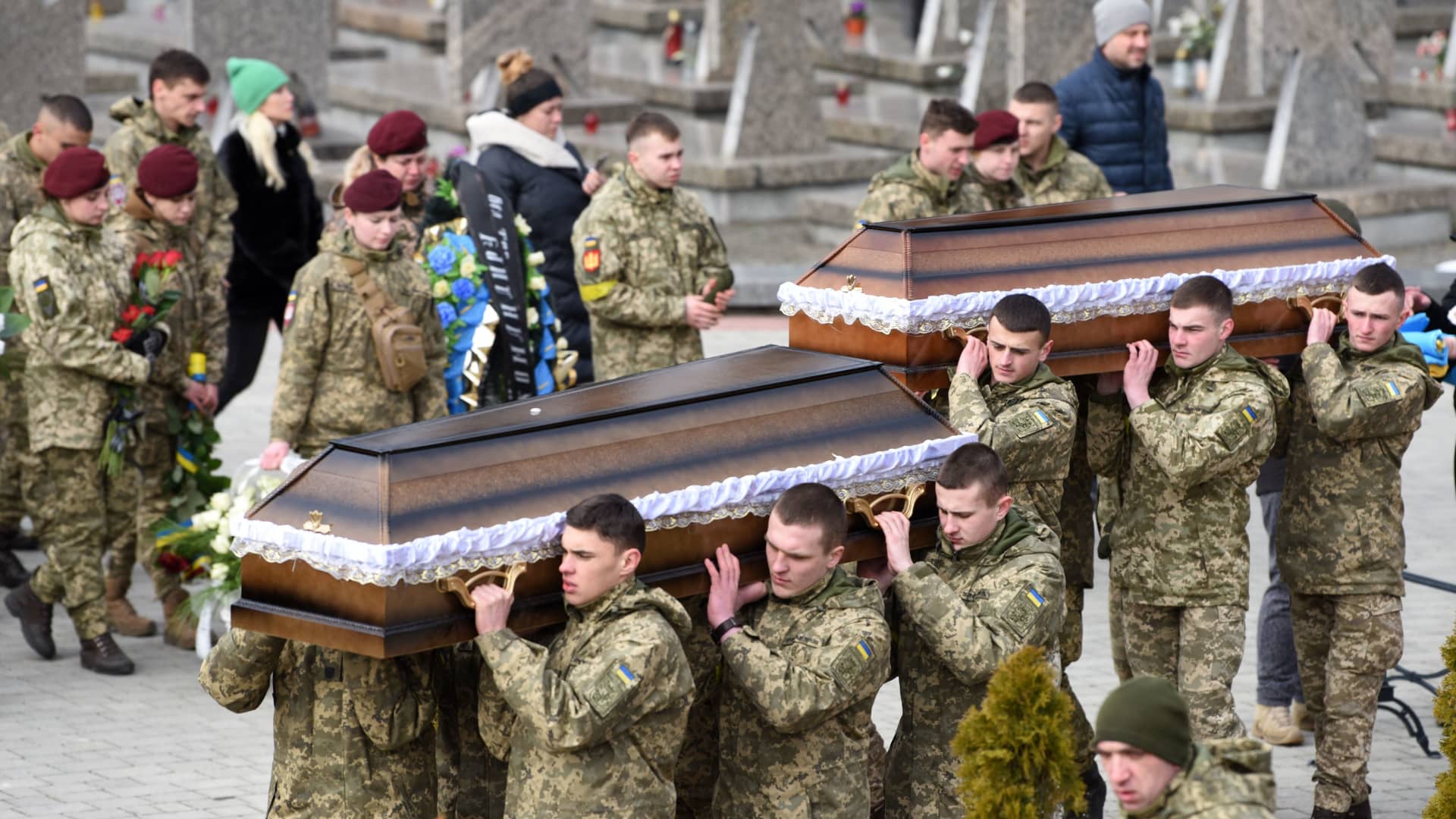 Servicemen carry coffins during funerals of Dmytro Kotenko, Vasyl Vyshyvany and Kyrylo Moroz, Ukrainian servicemen killed during Russia's invasion of Ukraine, at Lychakiv cemetery in the western Ukrainian city of Lviv on March 9, 2022.