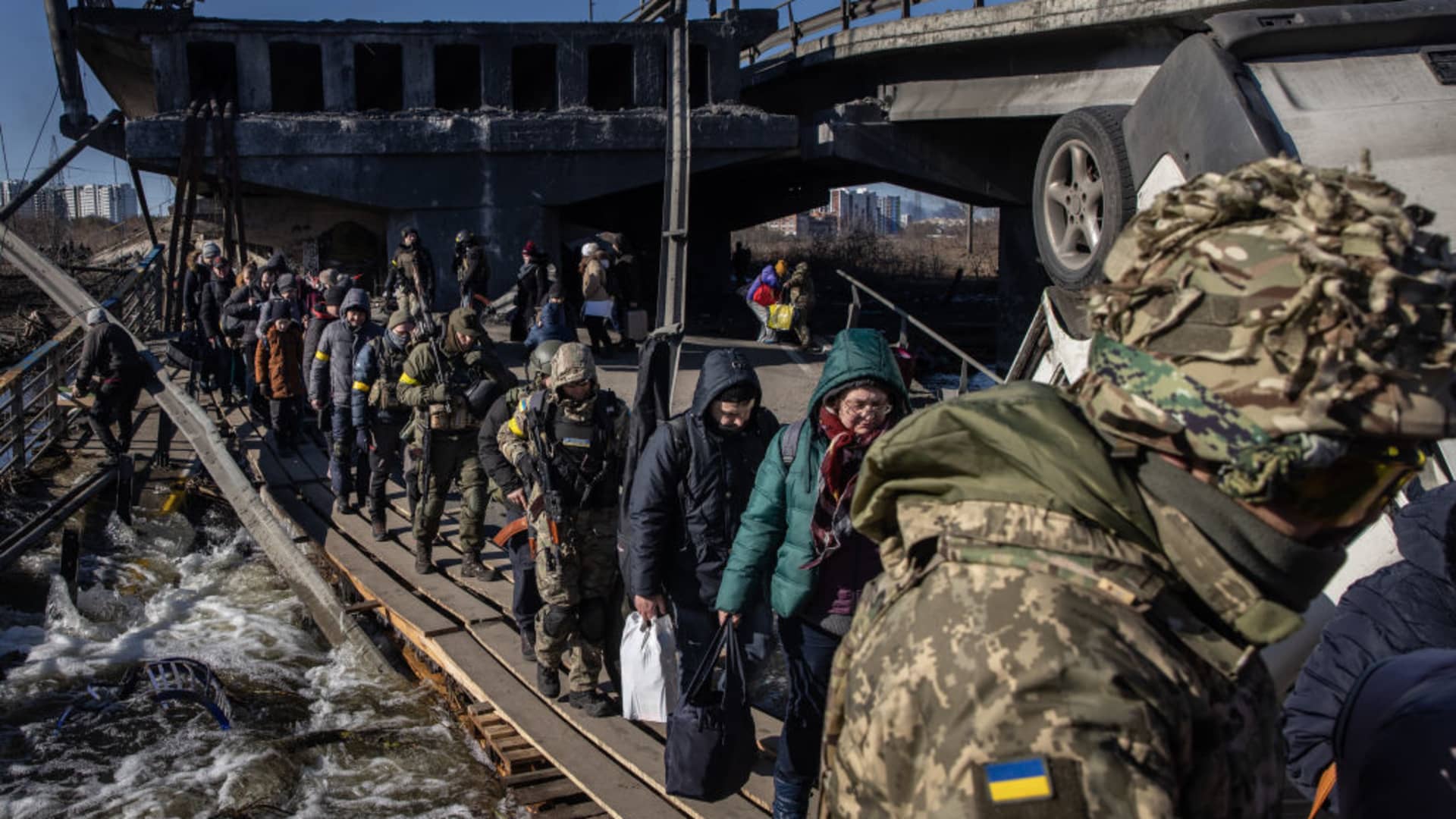 Residents of Irpin and Bucha flee fighting via a destroyed bridge on March 10, 2022 in Irpin, Ukraine. Irpin, a suburb northwest of Kyiv, had experienced days of sustained shelling by Russian forces advancing toward the capital. Well over two million people have fled Ukraine since Russia launched its attack on February 24.