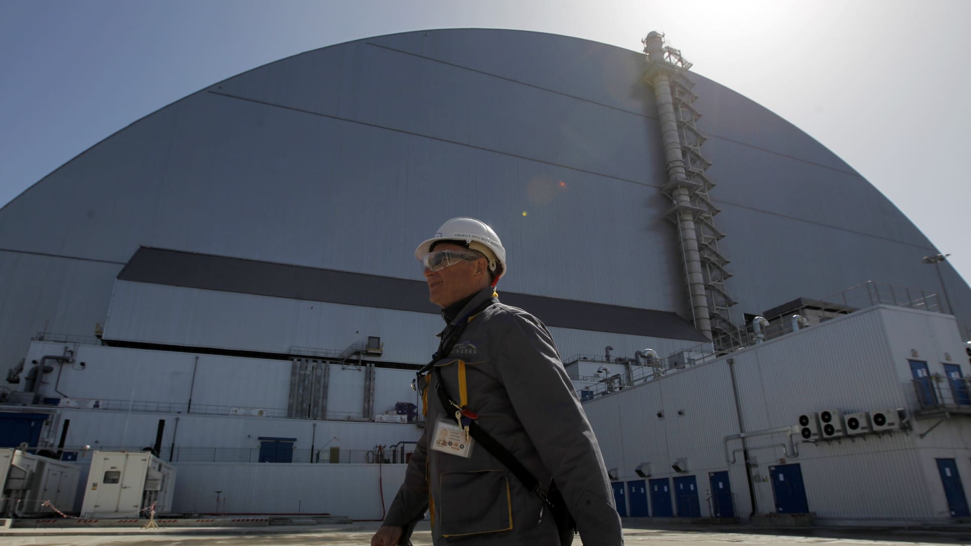 A worker walks in front of new protective shelter over the 4 nuclear reactor Unit at Chernobyl nuclear power plant in Kiev region, Ukraine, on 26 April, 2019.