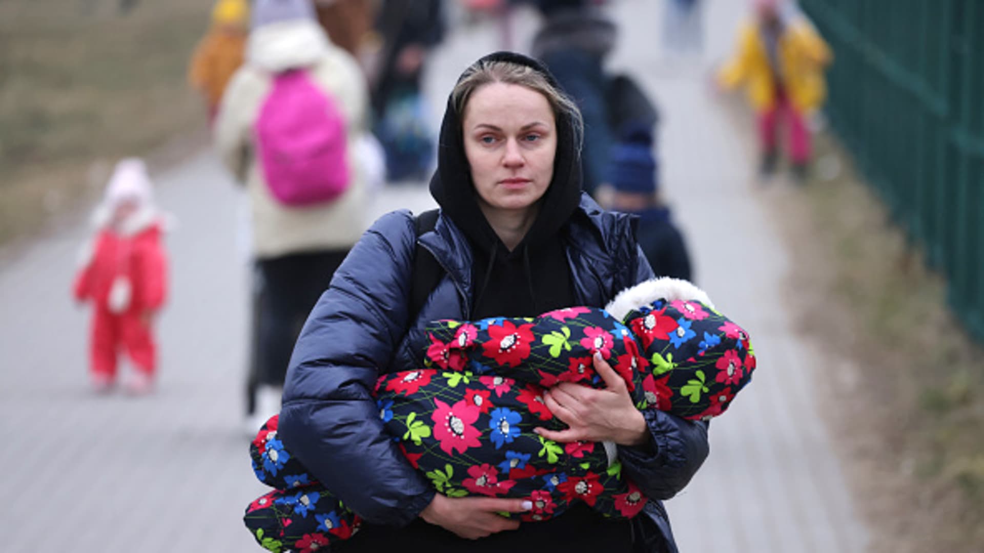 Women and children from war-torn Ukraine, including a mother carrying an infant, arrive in Poland at the Medyka border crossing on March 04, 2022.