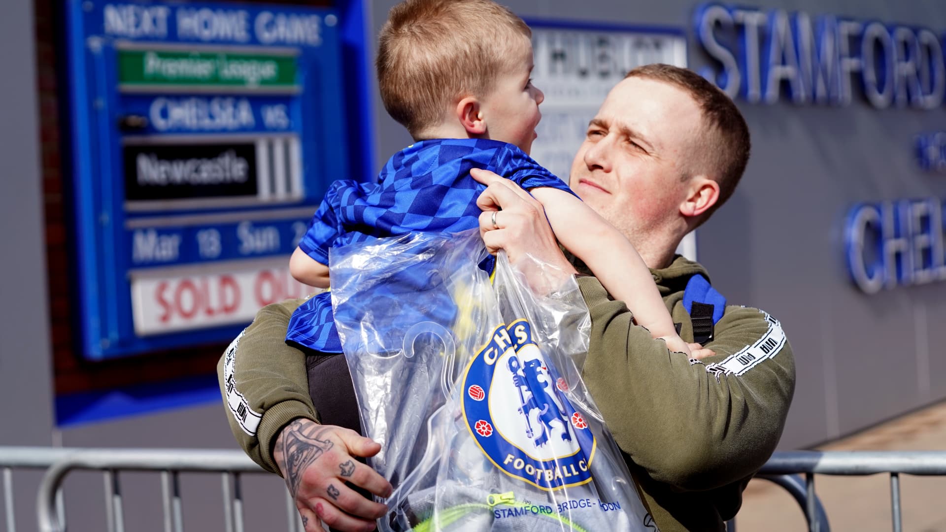 Martyn Hardiman with his son Peter, 2, after purchasing the last club shirt before the store closed, following the sanctioning of Roman Abramovich by the UK Government.
