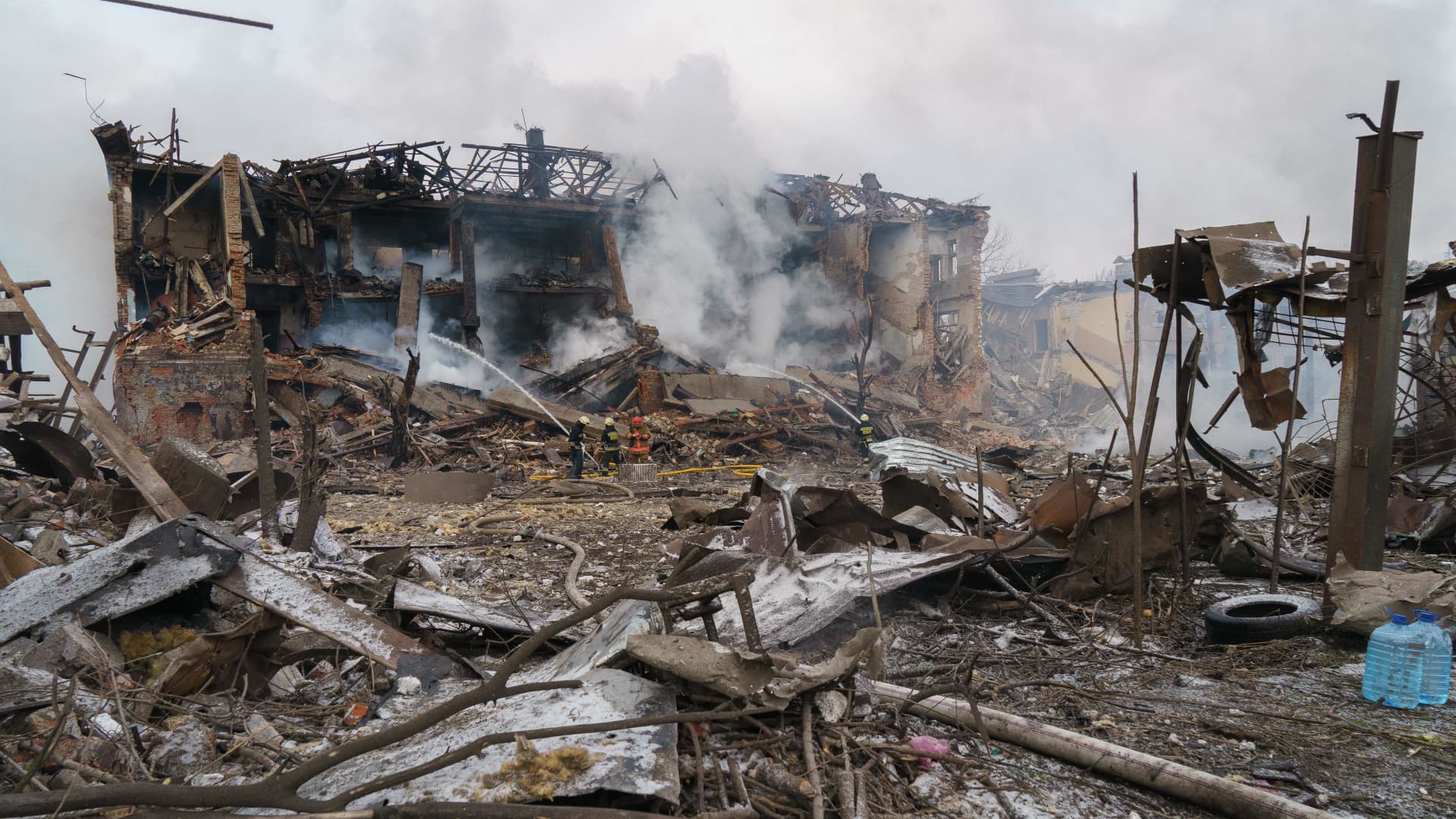 Firefighters spray water on a destroyed shoe factory following an airstrike in Dnipro on March 11, 2022.