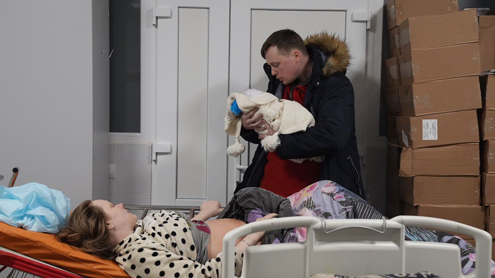 Mariana Vishegirskaya lies in a hospital bed after giving birth to her daughter Veronika, held by her husband Yuri, in Mariupol, Ukraine, Friday, March 11, 2022. Vishegirskaya survived the Russian airstrike on a children's and maternity hospital in Mariupol last Wednesday.