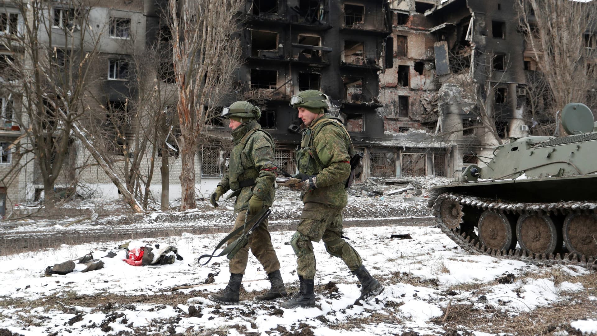Service members of pro-Russian troops in uniforms without insignia walk near a residential building which was heavily damaged during Ukraine-Russia conflict in the separatist-controlled town of Volnovakha in the Donetsk region, Ukraine March 11, 2022.