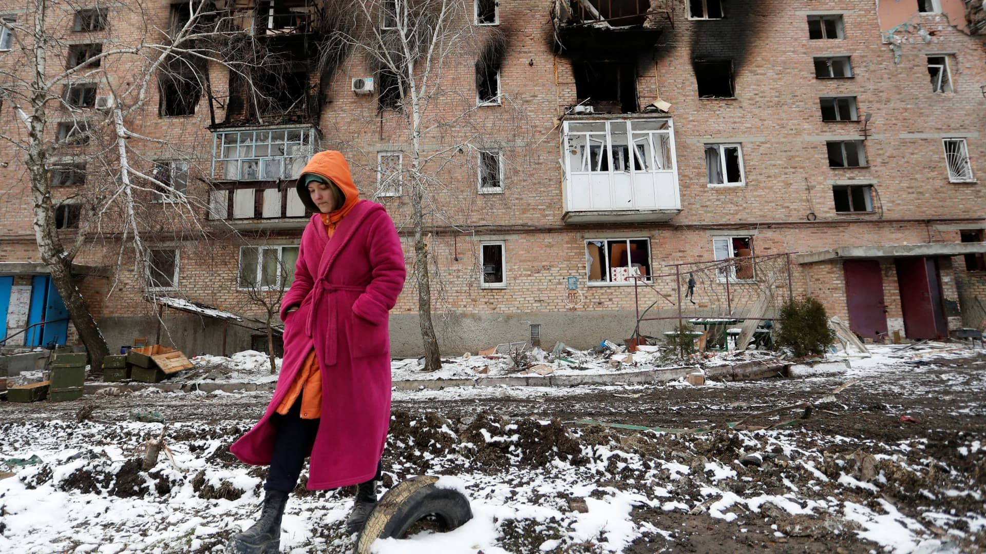 A woman walks in front of a residential building which was damaged during Ukraine-Russia conflict in the separatist-controlled town of Volnovakha in the Donetsk region, Ukraine March 11, 2022.