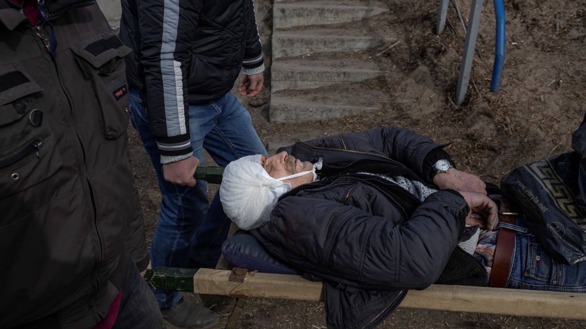 A wounded man is evacuated as Russia's invasion of Ukraine, in the town of Irpin outside Kyiv, Ukraine, March 12, 2022.