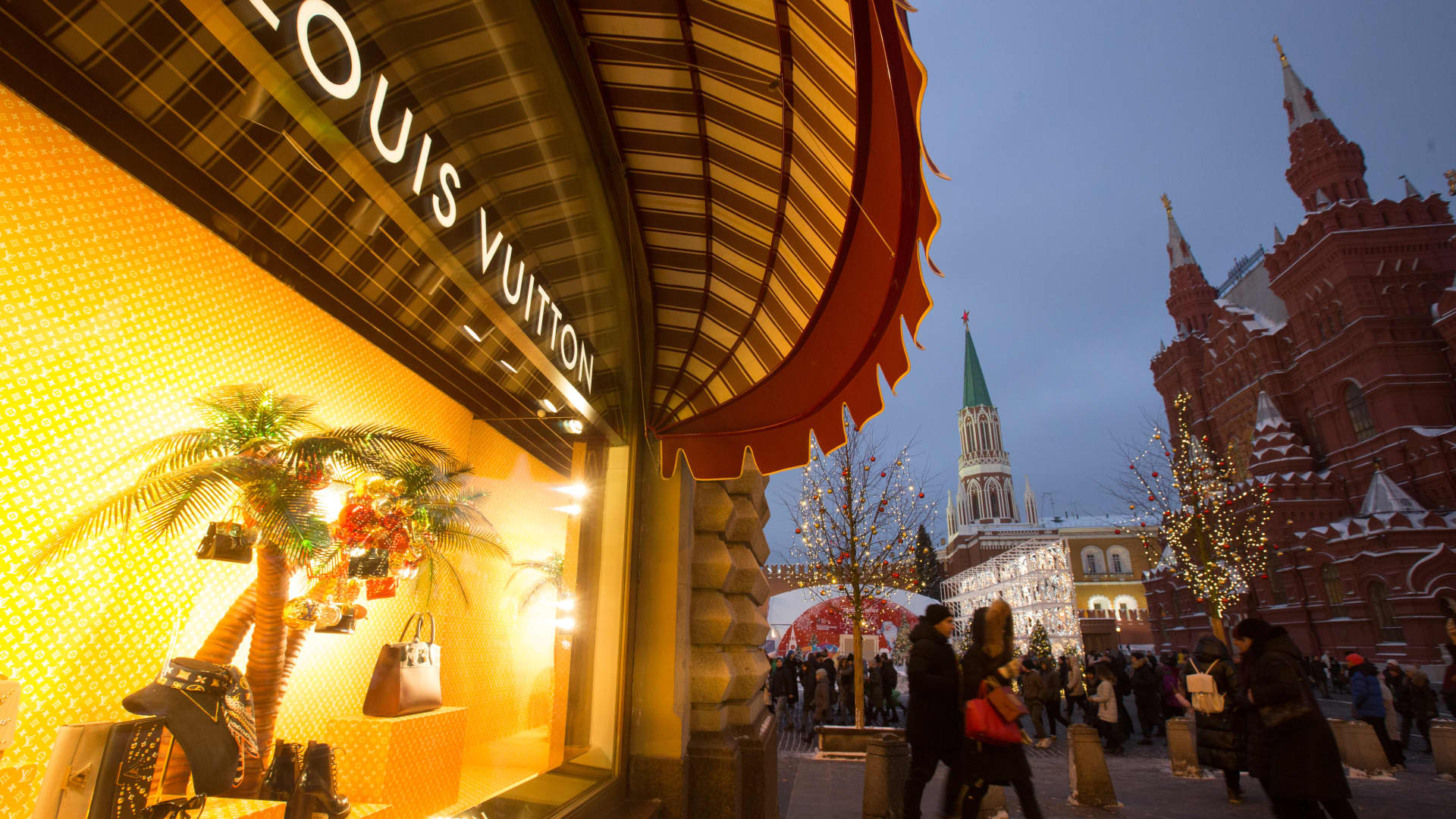 Pedestrians pass a LVMH Moet Hennessy Louis Vuitton SE window display outside the luxury GUM department store on Red Square in Moscow, Russia.