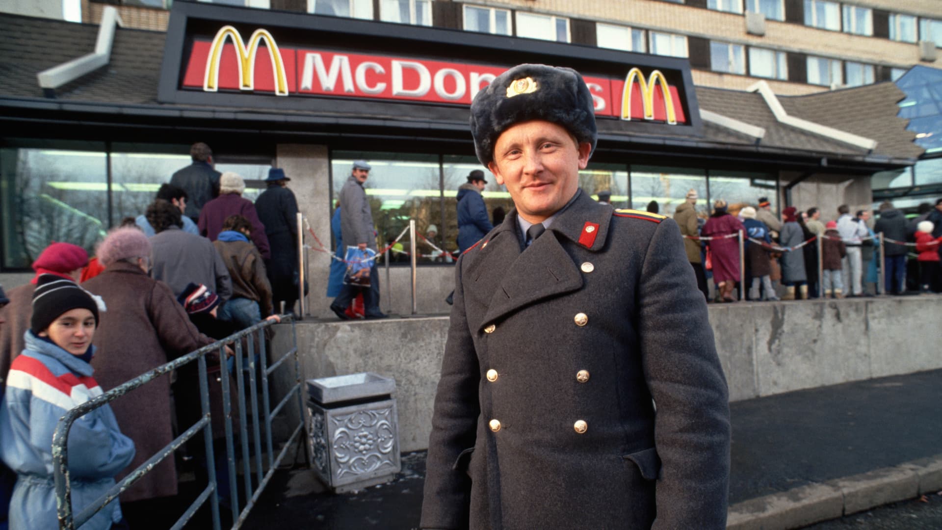A Soviet policeman stands by a queue of people waiting to enter a newly opened McDonald's on Gorky Street in Moscow in 1990.