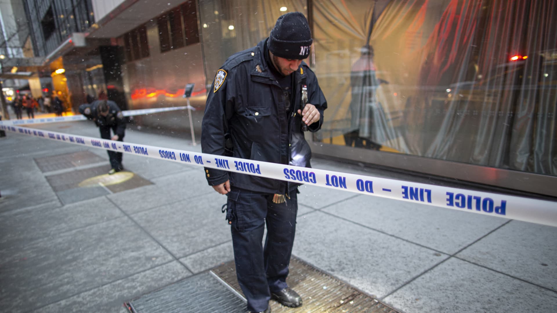 A New York City police officer looks on the ground next to the entrance of the Museum of Modern Art in New York City on March 12, 2022.