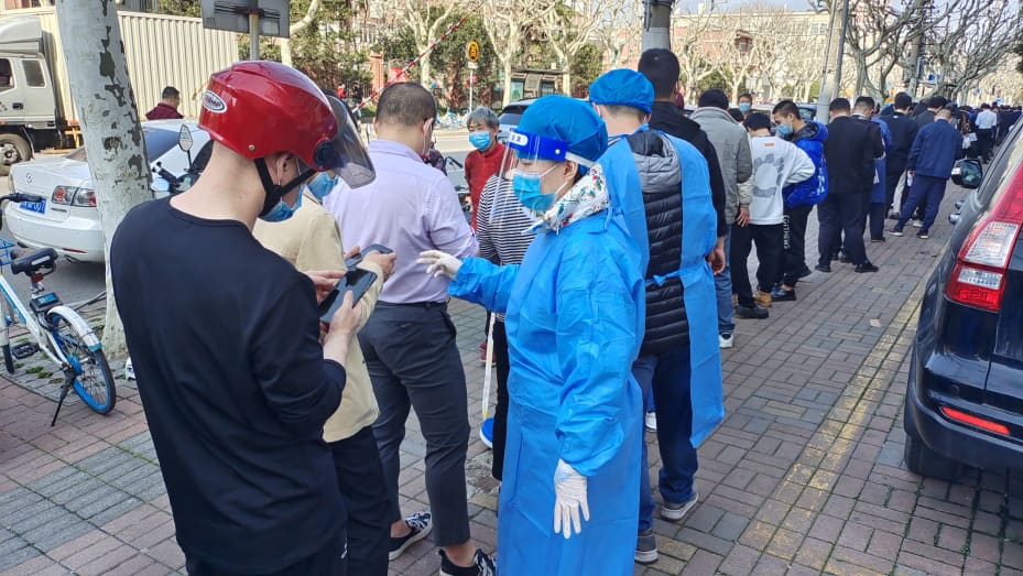 People wait in line for nucleic acid samples in Shanghai, China, March 12, 2022.