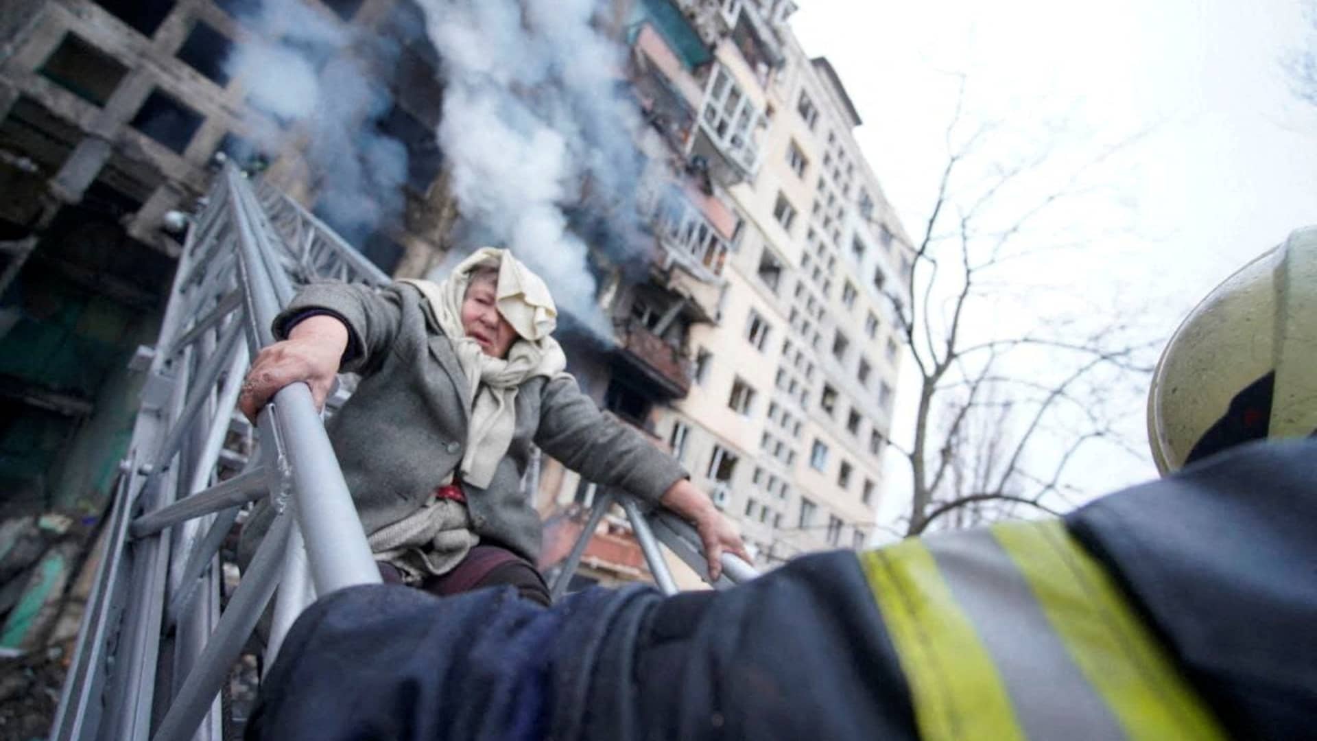 Rescuers work to get a woman out of a residential building that was struck, as Russia's attack on Ukraine continues, in Kyiv, Ukraine, in this handout picture released March 14, 2022. 