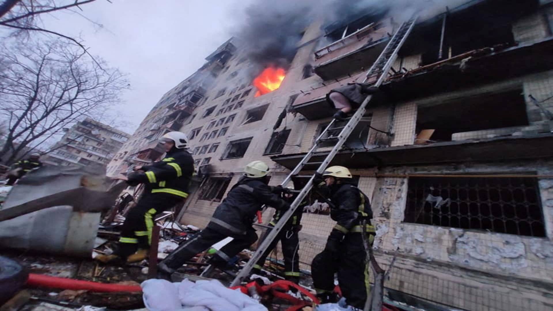 Rescuers help a local resident to be evacuated from a building damaged by shelling, as Russia's attack on Ukraine continues, in Kyiv, Ukraine, in this handout picture released March 14, 2022. 