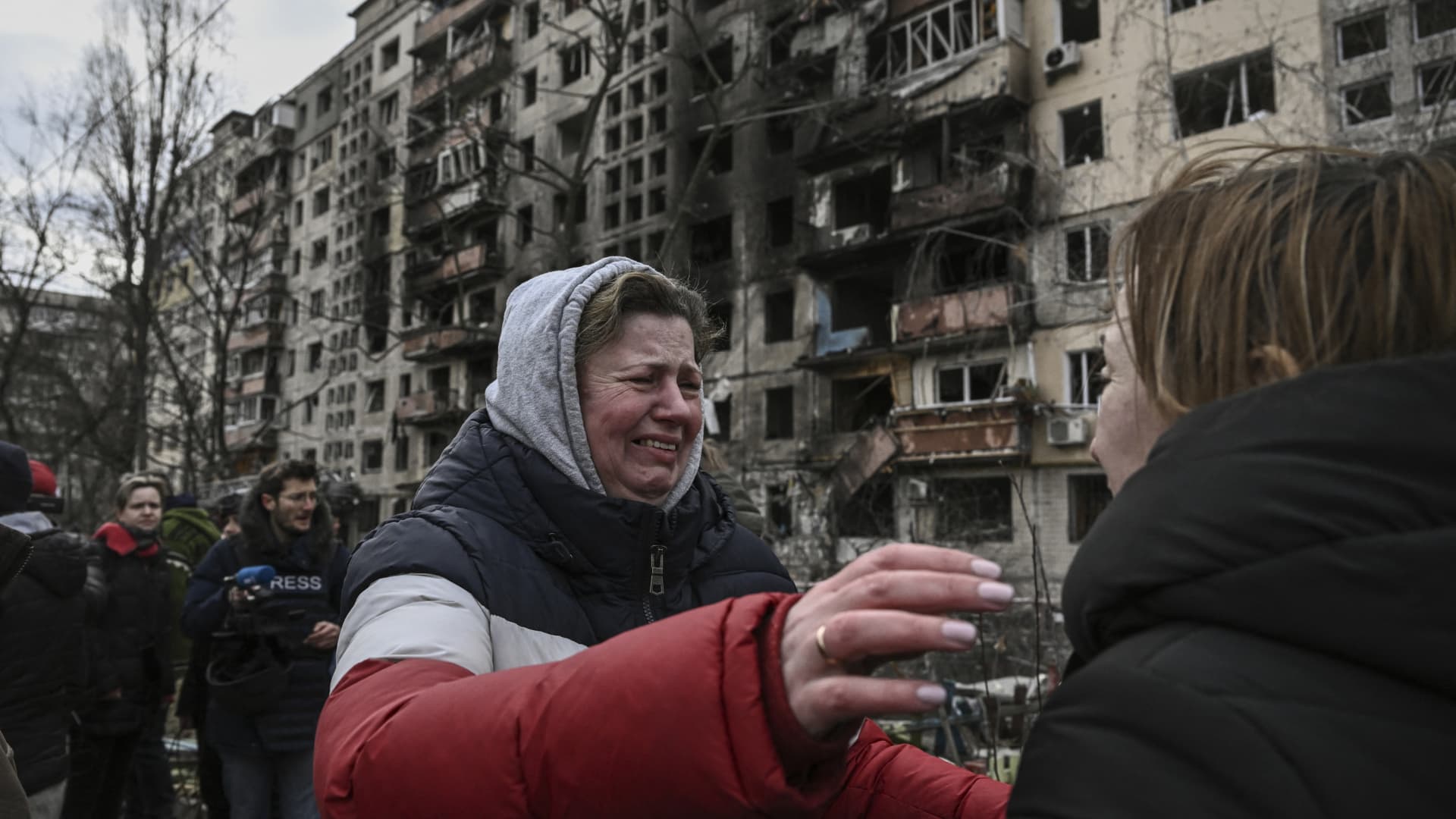 A woman reacts as she stands outside destroyed apartment blocks following shelling in Kyiv on March 14, 2022.