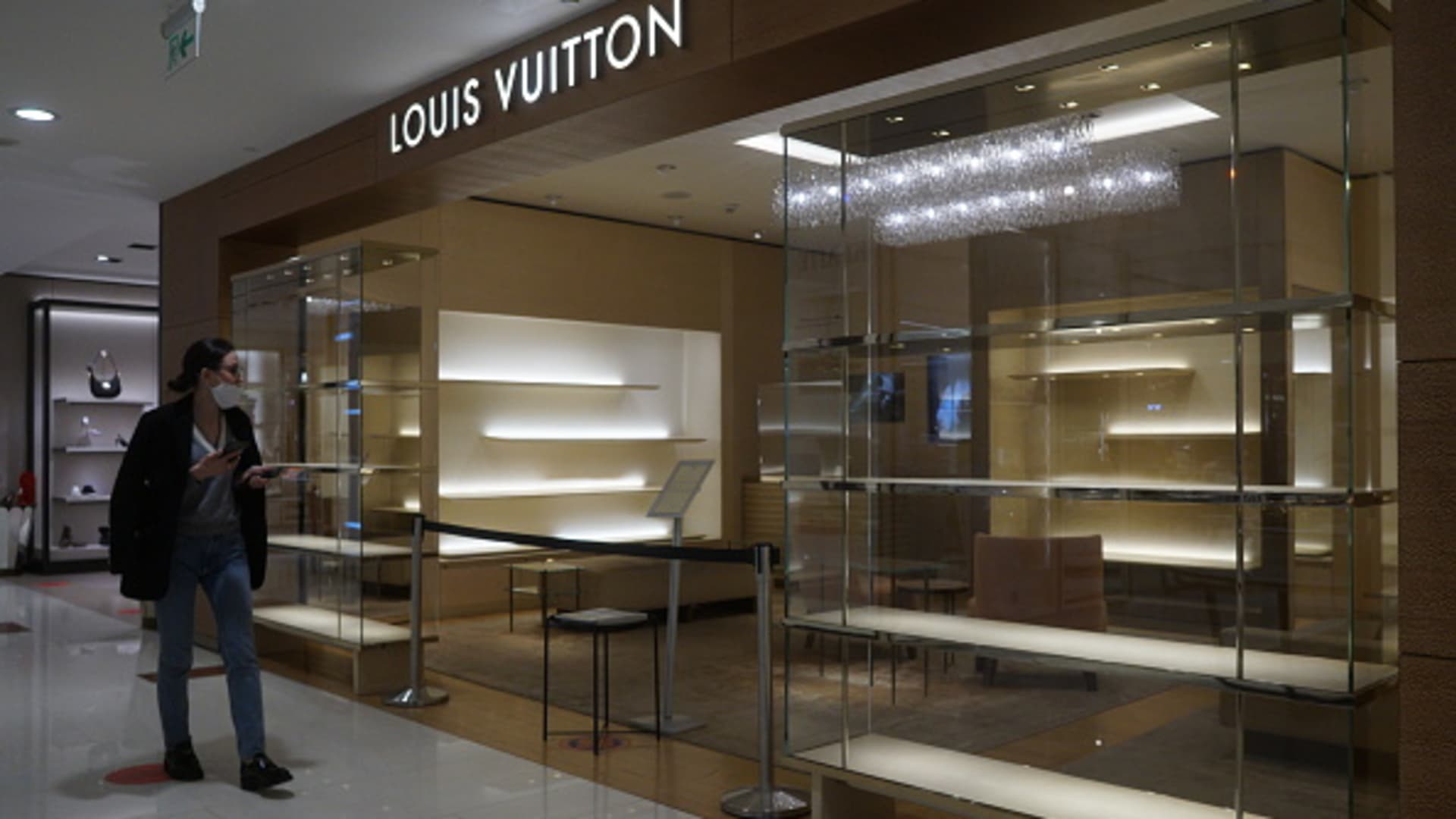 A woman looks at a closed Louis Vuitton store, which decided to temporarily close its stores in Russia, at a shopping mall on March 9, 2022 in Moscow, Russia.