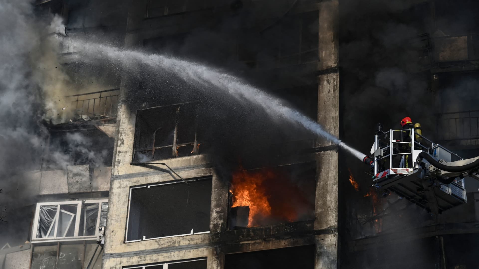 Firefighters extinguish a fire in an apartment building in Kyiv on March 15, 2022, after strikes on residential areas killed at least two people, Ukraine emergency services said as Russian troops intensified their attacks on the Ukrainian capital.