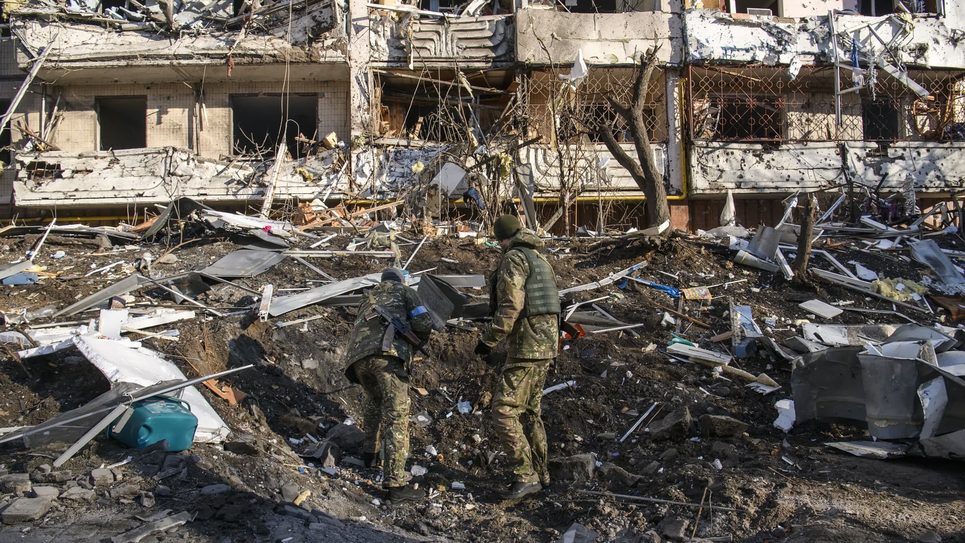 Police experts learn a funnel in the place of explosion of a wing missile near Residential apartment building in residential district of Kyiv after it was hit by shelling early morning as Russia's invasion of Ukraine continues, in Kyiv, Ukraine, March 15, 2022