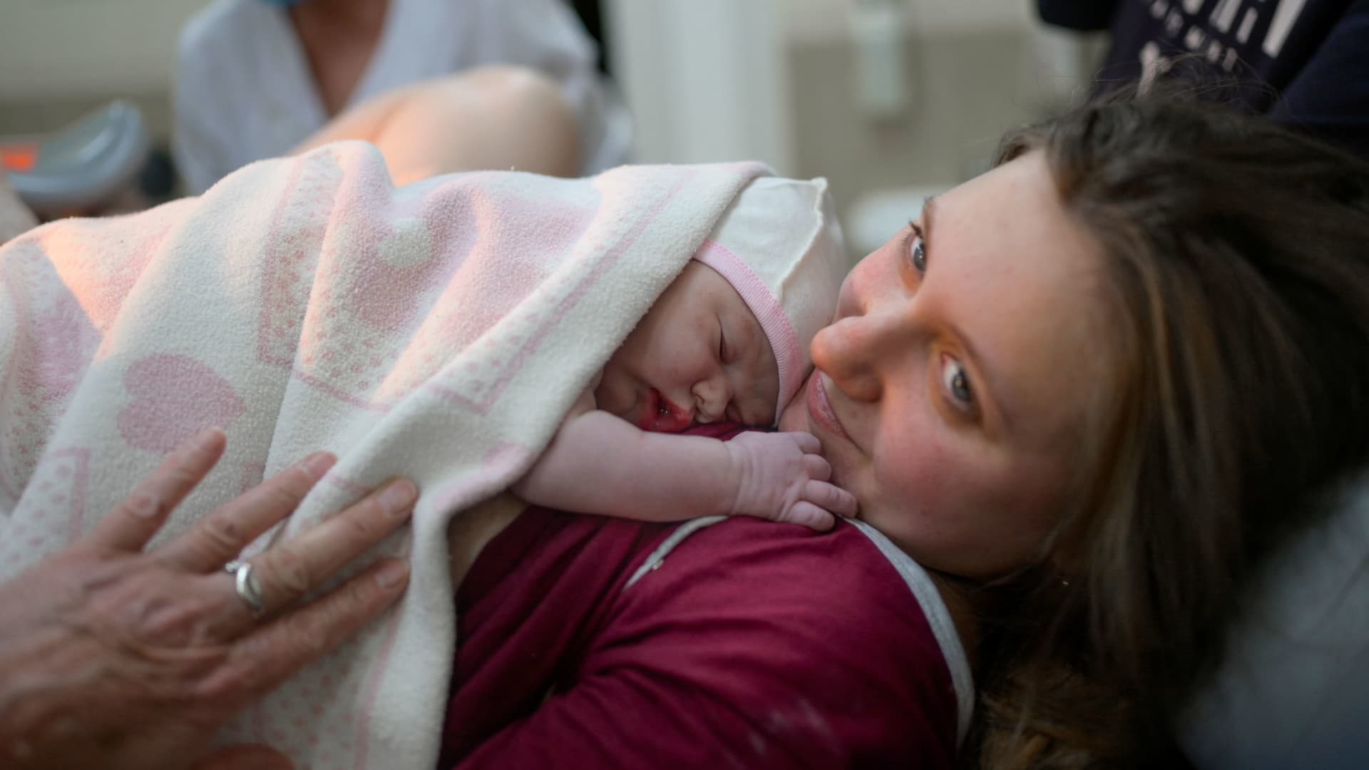 Aleina hugs her baby Snizhana after giving birth in the maternity ward as sirens warn of air raids in Mykolaiv, 14 March 2022.