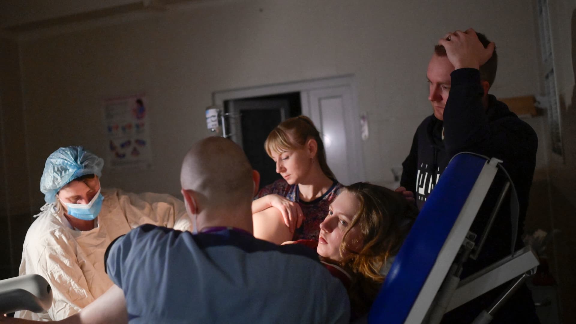 Aleina gives birth to her baby as nurses is helping her and her husband standing next to her in the maternity hospital in a basement of maternity hospital as sirens warning for air raids in Mykolaiv, on March 14, 2022.
