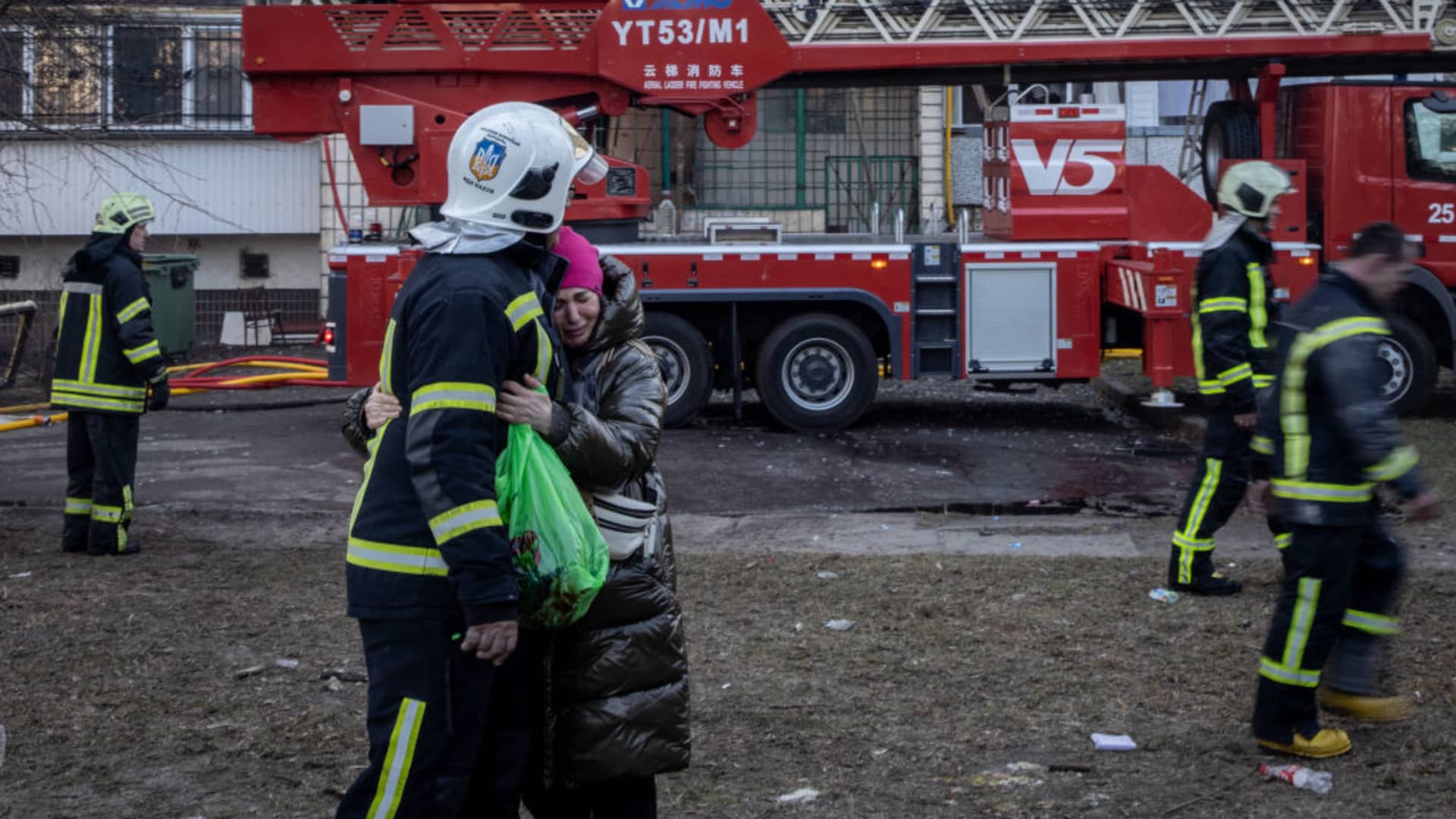 A resident is comforted by a firefighter at a residential apartment building after it was hit by a Russian attack in the early hours of the morning in the Sviatoshynskyi District on March 15, 2022 in Kyiv, Ukraine.