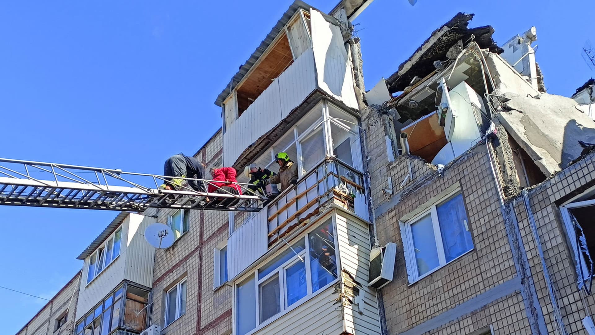 Rescuers evacuate a woman from a residential building damaged by an airstrike, as Russia?s attack on Ukraine continues, in Kharkiv, Ukraine March 15, 2022.