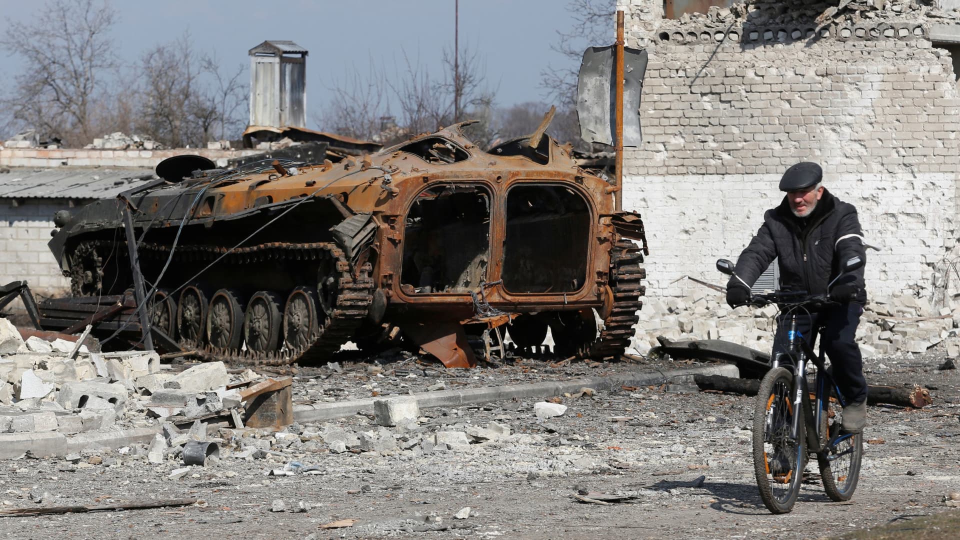A local resident rides a bicycle past a charred armoured vehicle during Ukraine-Russia conflict in the separatist-controlled town of Volnovakha in the Donetsk region, Ukraine March 15, 2022.