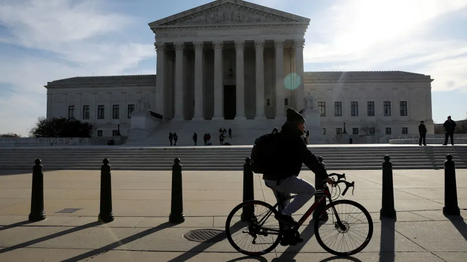A cyclist rides in front of the U.S. Supreme Court building in Washington, March 15, 2022.