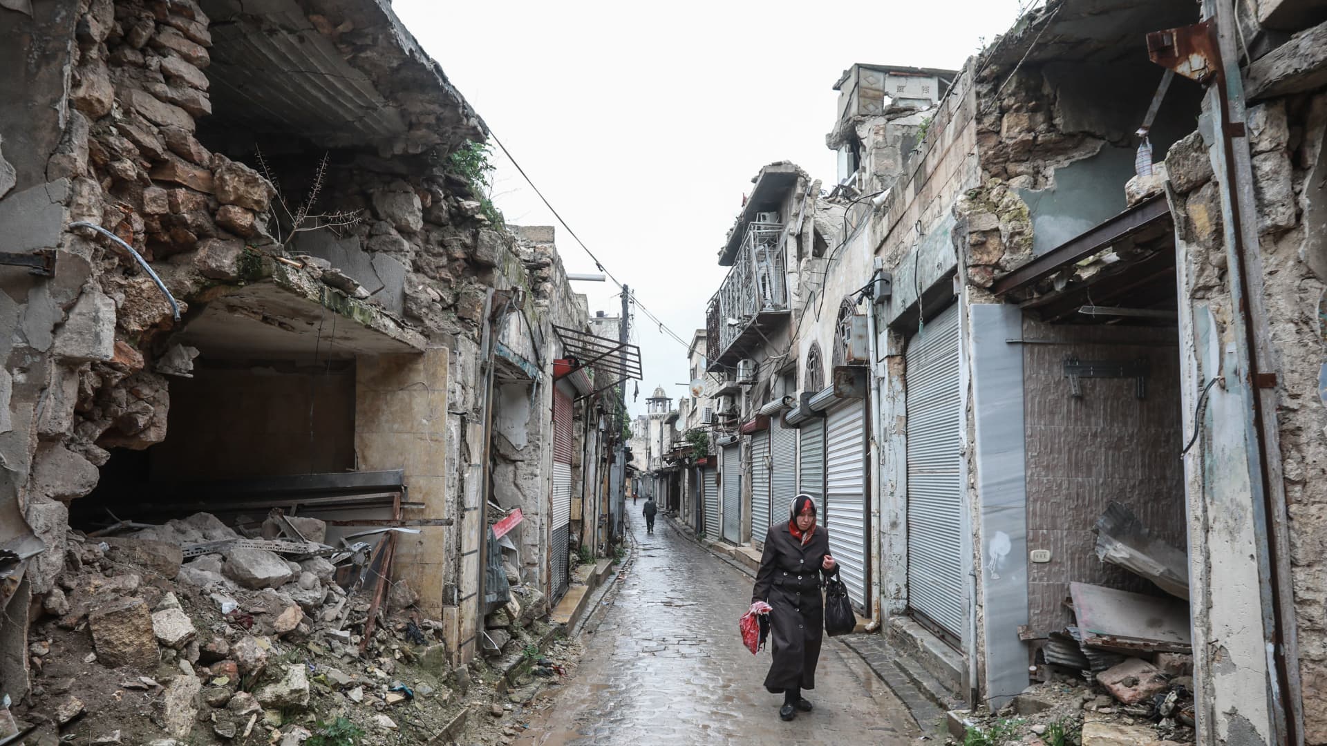 A Syrian woman walks amid destruction in the Bab al-Qinnasrin area in Aleppo's Old city, on February 10, 2019.