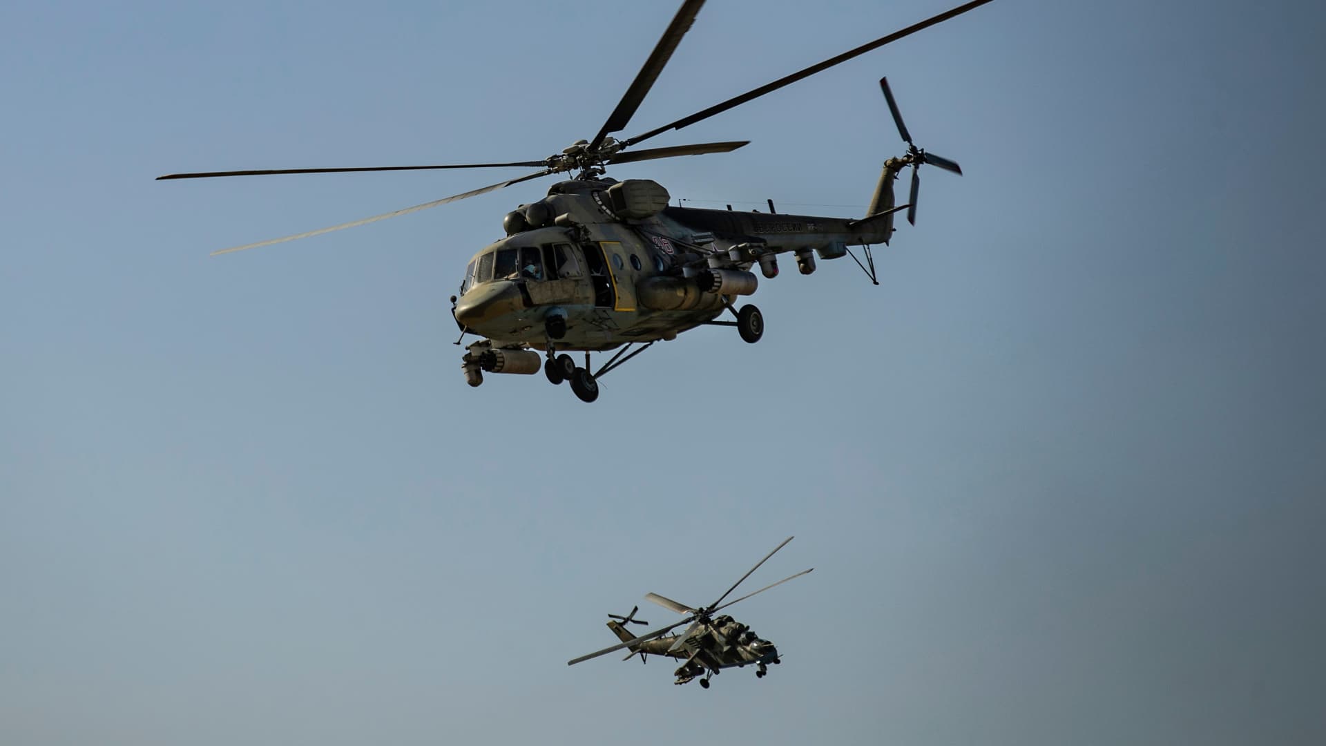 Russian Mil Mi-17 and Mil Mi-24military helicopters fly over the northeastern Syrian town of al-Malikiyahat the border with Turkey, on June 3, 2020.