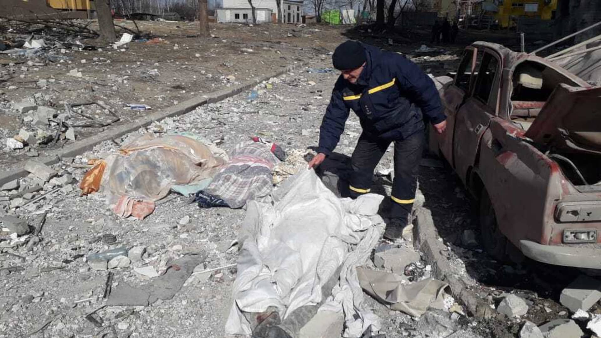 A man covers a dead body after a residential buildings hit by a Russian attack in Chernihiv, Ukraine on March 17, 2022.
