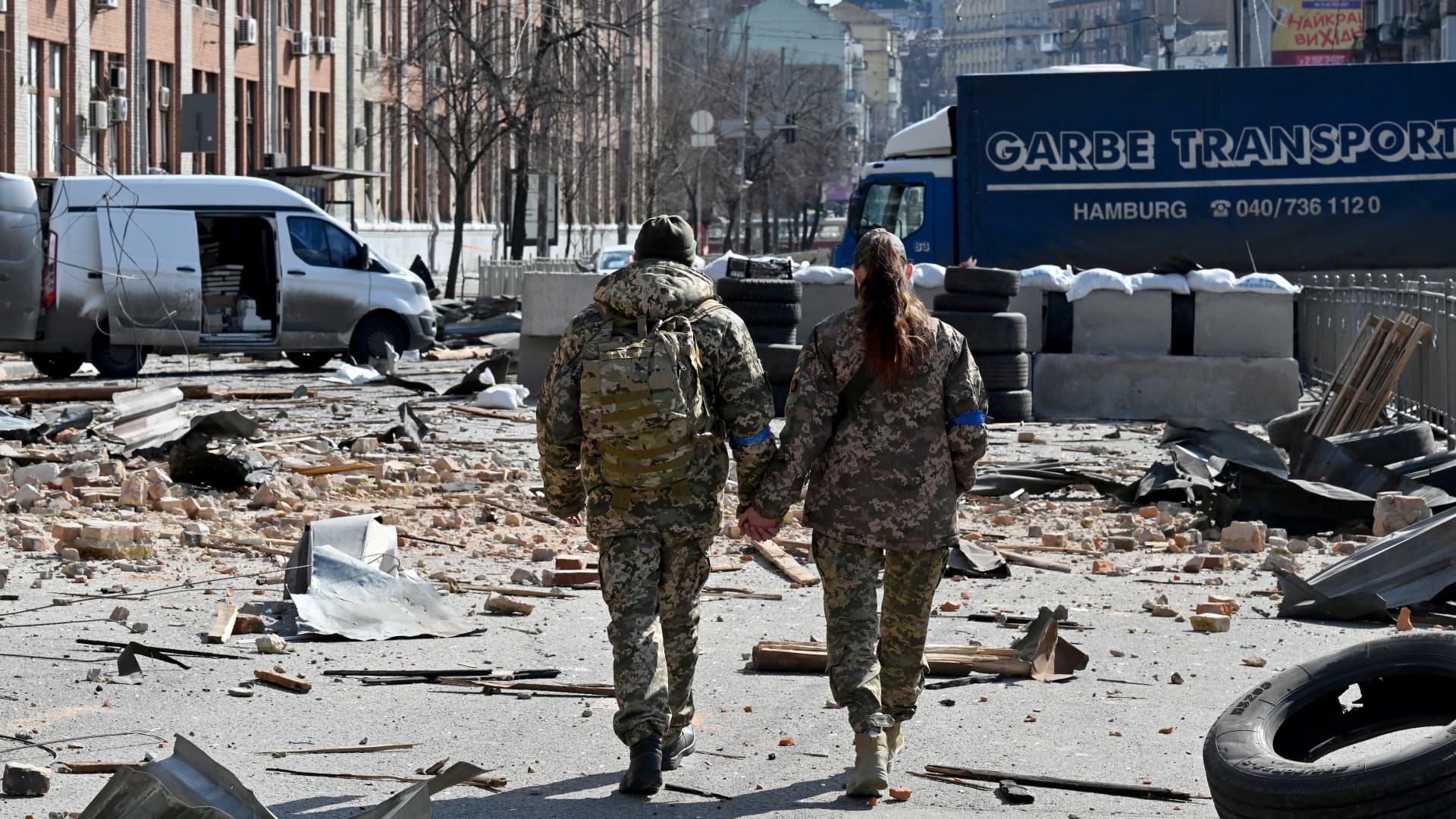 A couple of Ukrainian soldiers walks hand in hand amid Russian invasion of Ukraine in Kyiv on March 17, 2022, as Russian troops try to encircle the Ukrainian capital as part of their slow-moving offensive.